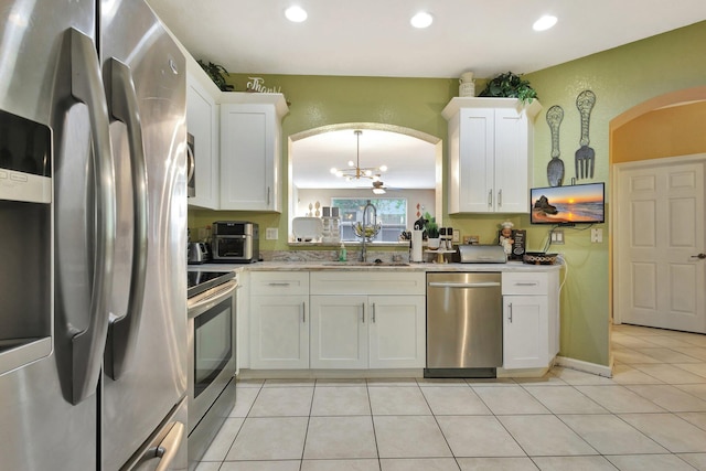 2125 Oakmont Dr, Riviera Beach, FL 33404 - kitchen featuring an inviting chandelier, a sink, stainless steel appliances, white cabinetry, and arched walkways