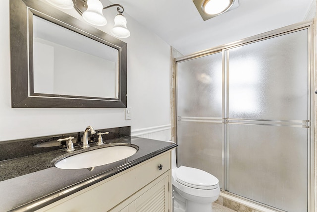 bathroom featuring a stall shower, vanity, and toilet