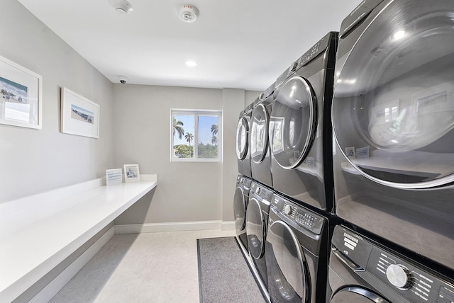 washroom with stacked washer / drying machine, baseboards, and recessed lighting