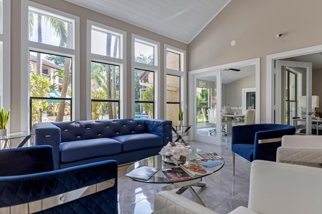 living room featuring plenty of natural light, french doors, high vaulted ceiling, and marble finish flooring