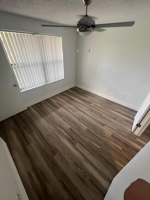 dining area with a textured ceiling, wood finished floors, ceiling fan, and baseboards
