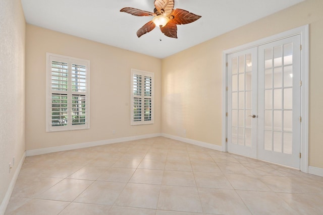 spare room with light tile patterned floors, french doors, baseboards, and ceiling fan