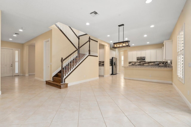 unfurnished living room featuring light tile patterned floors, visible vents, and recessed lighting