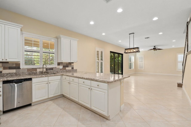 kitchen with a peninsula, light tile patterned floors, a sink, stainless steel dishwasher, and recessed lighting