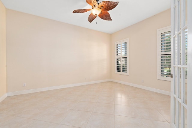 unfurnished room featuring baseboards, a ceiling fan, and light tile patterned floors