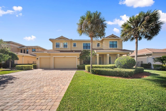 view of front of property with a front yard, stucco siding, an attached garage, and decorative driveway