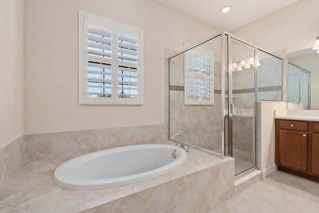 bathroom featuring a stall shower, vanity, a bath, and tile patterned flooring