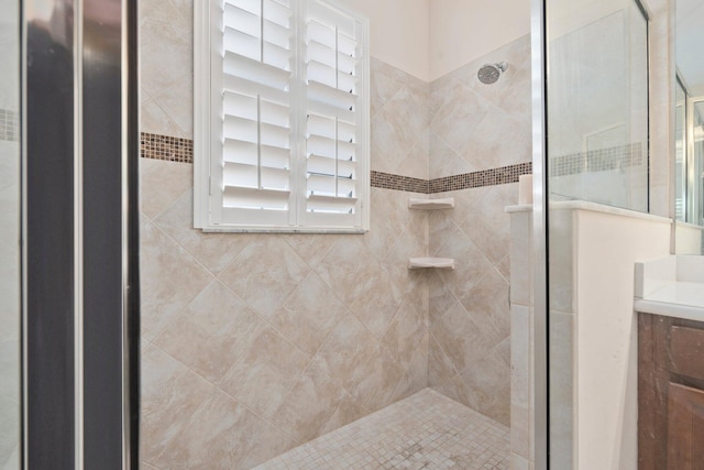 bathroom with a shower stall and vanity