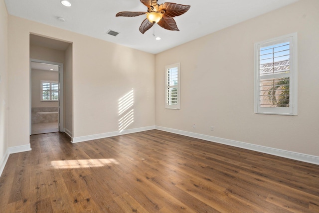 empty room with ceiling fan, hardwood / wood-style flooring, baseboards, and visible vents
