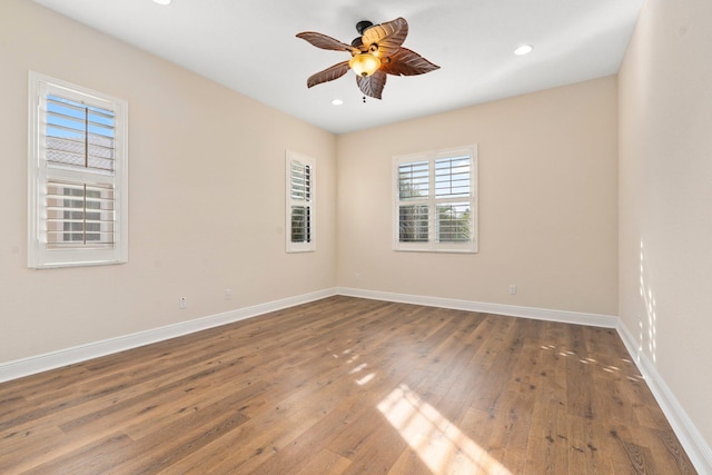 spare room with baseboards, recessed lighting, ceiling fan, and wood finished floors