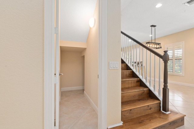 stairway featuring baseboards, visible vents, recessed lighting, tile patterned floors, and a notable chandelier