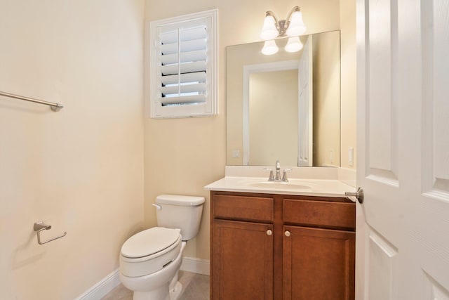 bathroom with vanity, toilet, and baseboards