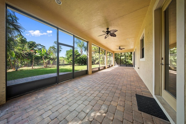 unfurnished sunroom with a ceiling fan