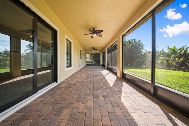 unfurnished sunroom featuring a wealth of natural light and ceiling fan
