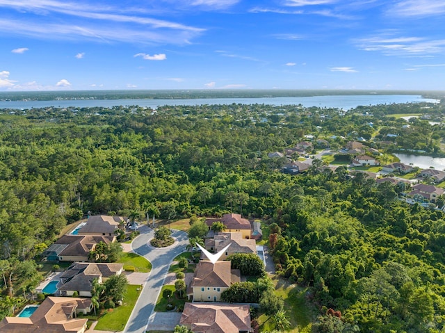 bird's eye view with a water view, a view of trees, and a residential view