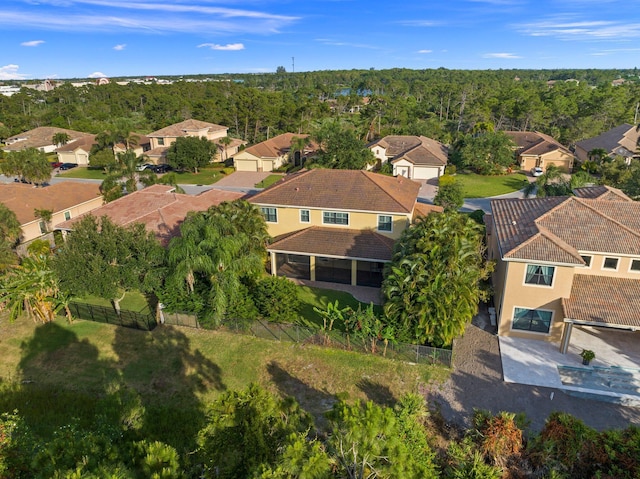 drone / aerial view featuring a wooded view and a residential view