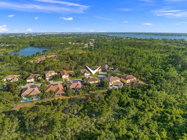bird's eye view with a water view, a view of trees, and a residential view