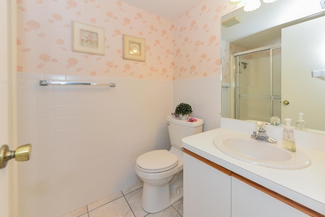bathroom featuring toilet, vanity, a shower stall, wainscoting, and wallpapered walls