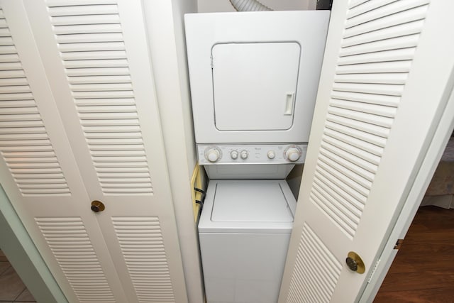 laundry area featuring laundry area, stacked washer / dryer, and wood finished floors