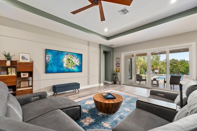 living area featuring wood finished floors, a ceiling fan, visible vents, baseboards, and recessed lighting