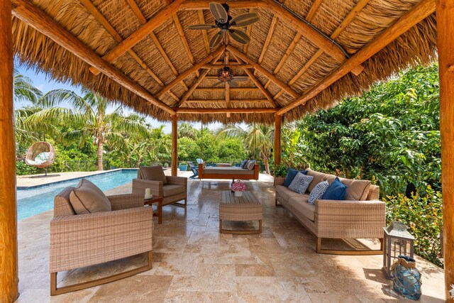 view of patio / terrace with an outdoor living space, a gazebo, an outdoor pool, and a ceiling fan
