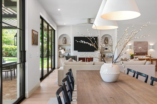 dining room with plenty of natural light, built in features, light wood-style floors, and recessed lighting