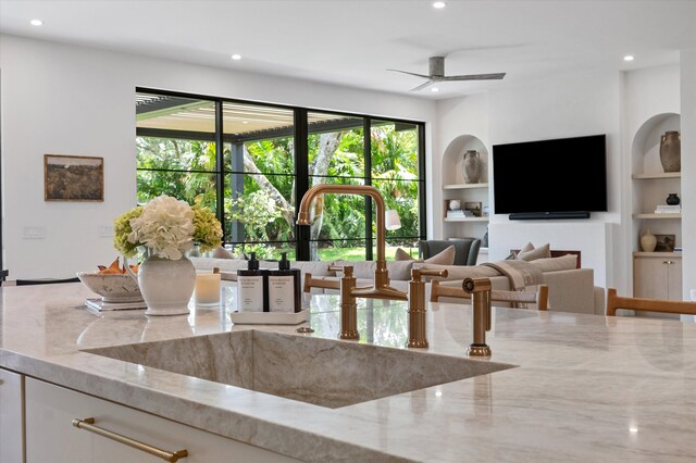 interior space featuring a sink, light stone counters, recessed lighting, built in features, and ceiling fan
