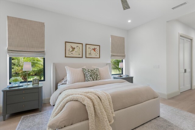bedroom with multiple windows, light wood-type flooring, baseboards, and recessed lighting