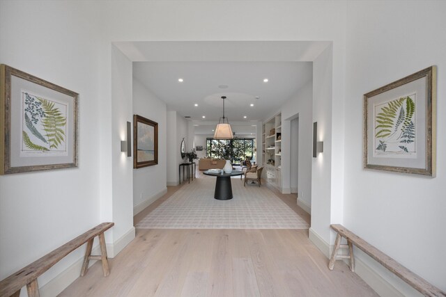 corridor featuring light wood finished floors, recessed lighting, and baseboards