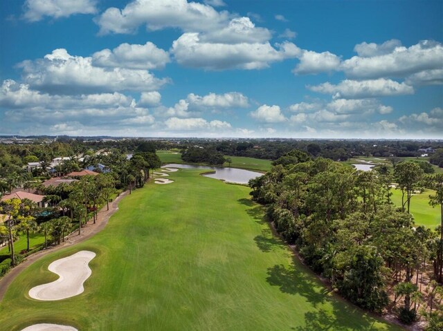 bird's eye view of a large body of water, a golf course, and a tree filled landscape