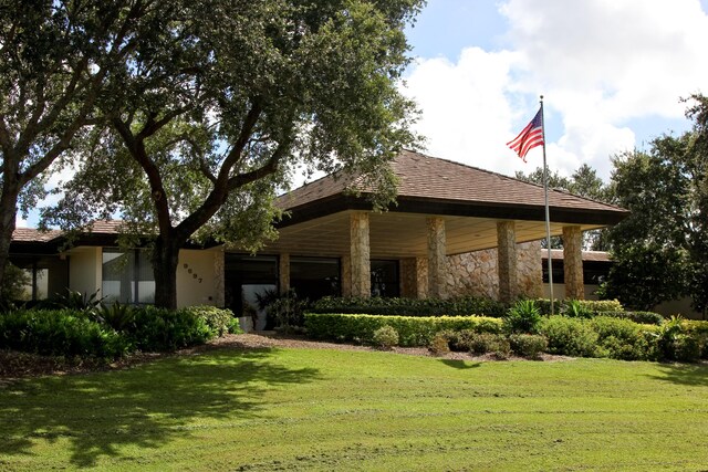 view of front of home with stone siding and a front yard