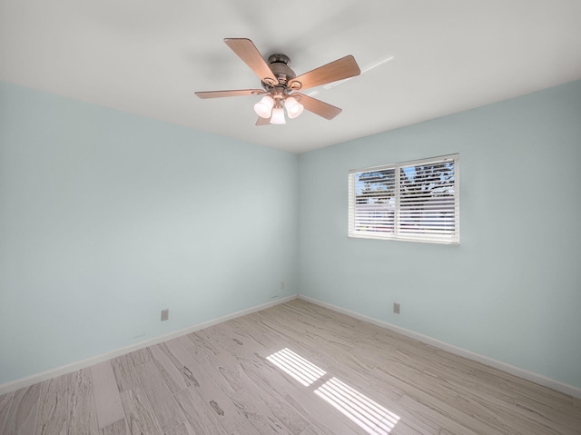 spare room featuring light wood-style floors, baseboards, and ceiling fan