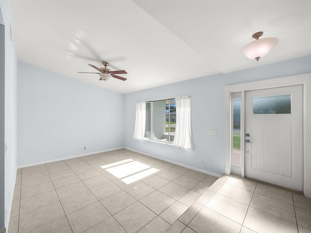 tiled entrance foyer with baseboards and ceiling fan
