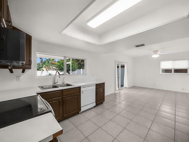 kitchen featuring white dishwasher, a sink, light countertops, light tile patterned flooring, and a ceiling fan