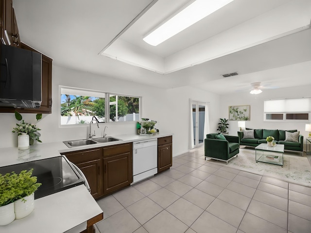 kitchen with dishwasher, a sink, light countertops, light tile patterned floors, and black range with electric cooktop