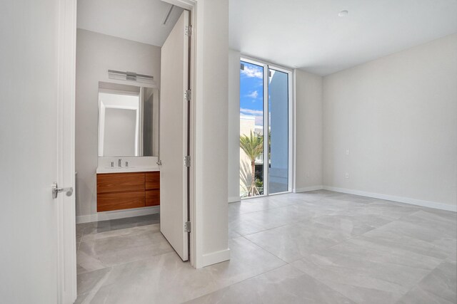 220 SE Mizner Blvd Unit Ph920, Boca Raton, FL 33432 - unfurnished bedroom featuring baseboards, access to outside, a sink, a wall of windows, and connected bathroom