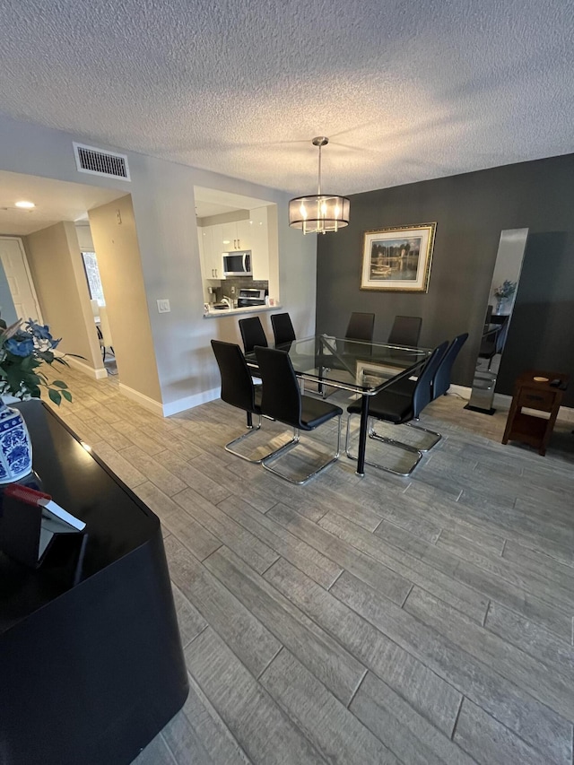 7340 Amberly Ln # 205, Delray Beach, FL 33446 - living area featuring a textured ceiling, visible vents, and wood finished floors