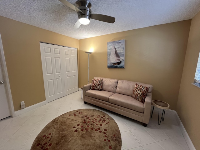 7340 Amberly Ln # 205, Delray Beach, FL 33446 - living room featuring light tile patterned floors, baseboards, ceiling fan, and a textured ceiling