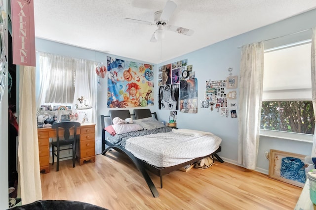 654 Bunting Dr, Delray Beach, FL 33444 - bedroom with a textured ceiling, baseboards, wood finished floors, and a ceiling fan
