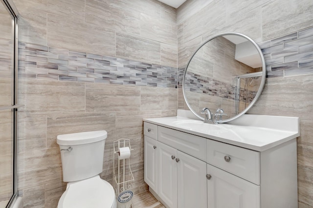 654 Bunting Dr, Delray Beach, FL 33444 - bathroom featuring tile walls, toilet, vanity, and a shower with shower door