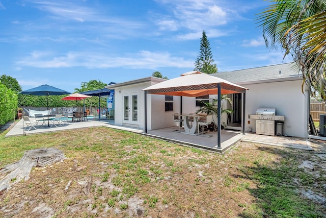 654 Bunting Dr, Delray Beach, FL 33444 - back of property with a patio, french doors, stucco siding, fence, and a gazebo