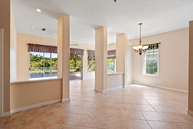 4922 SE Heartleaf Ter, Hobe Sound, FL 33455 - unfurnished room with a chandelier, light tile patterned flooring, baseboards, recessed lighting, and a textured ceiling