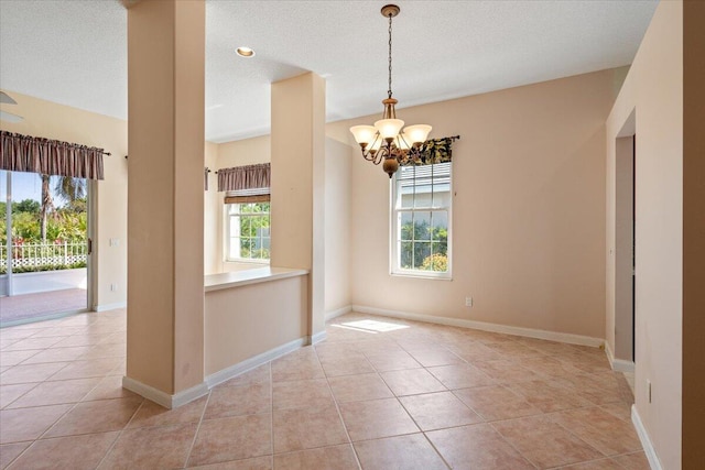 4922 SE Heartleaf Ter, Hobe Sound, FL 33455 - spare room featuring a chandelier, light tile patterned flooring, and baseboards