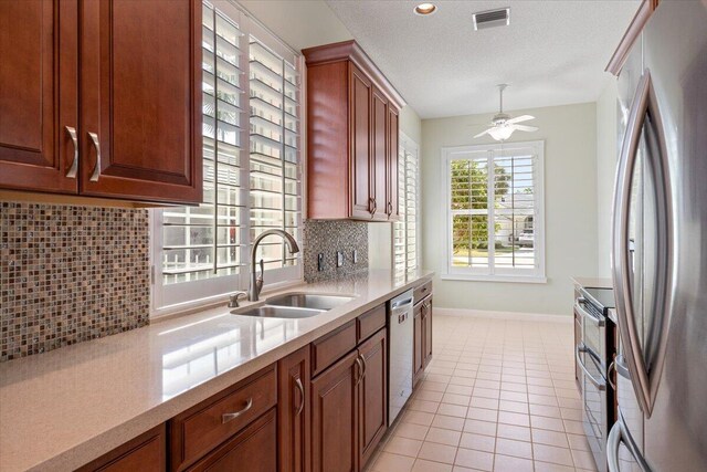 4922 SE Heartleaf Ter, Hobe Sound, FL 33455 - kitchen featuring appliances with stainless steel finishes, a sink, backsplash, baseboards, and a ceiling fan