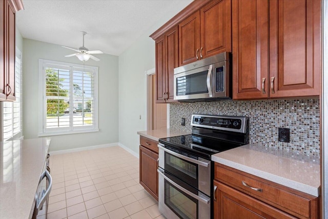 4922 SE Heartleaf Ter, Hobe Sound, FL 33455 - kitchen with appliances with stainless steel finishes, tasteful backsplash, light countertops, ceiling fan, and light tile patterned floors