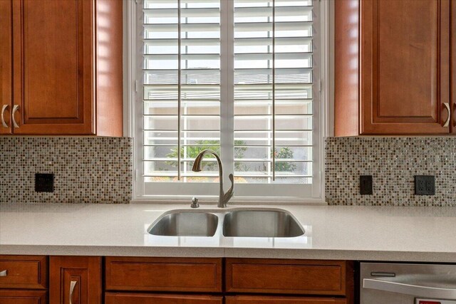 4922 SE Heartleaf Ter, Hobe Sound, FL 33455 - kitchen with dishwasher, a sink, backsplash, and brown cabinetry