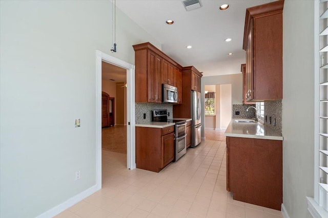 4922 SE Heartleaf Ter, Hobe Sound, FL 33455 - kitchen featuring appliances with stainless steel finishes, a sink, backsplash, light countertops, and recessed lighting