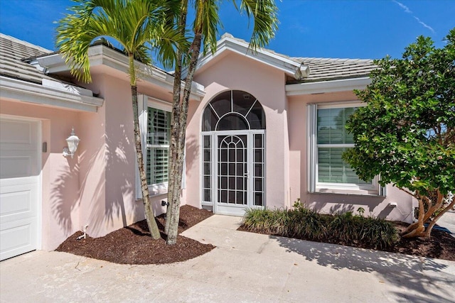 4922 SE Heartleaf Ter, Hobe Sound, FL 33455 - doorway to property featuring stucco siding and a tile roof