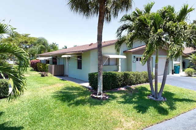 view of home's exterior featuring a garage, stucco siding, driveway, and a lawn