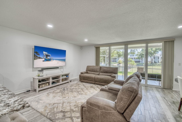 living area featuring a textured ceiling, recessed lighting, and wood finished floors